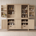 A large light oak kitchen pantry cabinet with multiple doors and open shelves, styled with glass jars, bottles, bowls, and utensils, set against a paneled wall and wood floor.