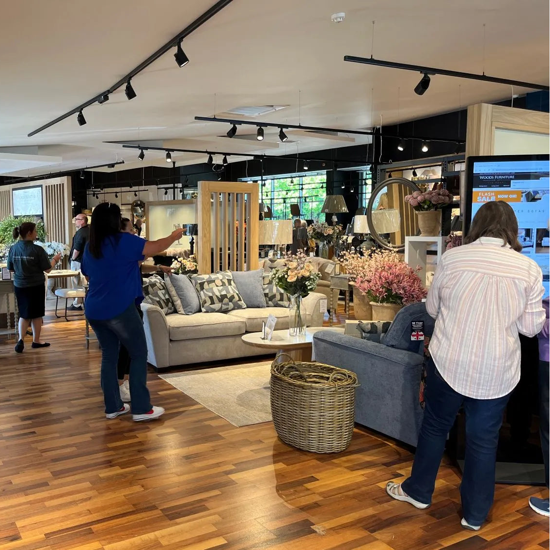 People shopping in a furniture store with various couches and decor items.