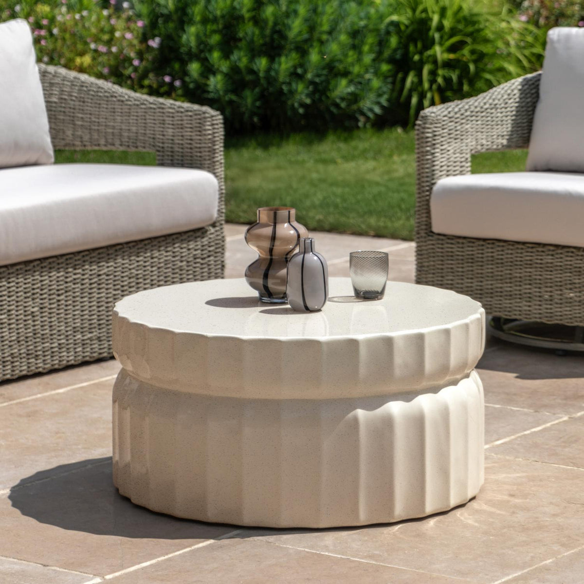 Round outdoor coffee table with decorative items in a patio setting