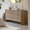 Wooden dresser with decorative items in a room setting