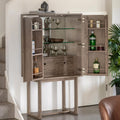 Wooden bar cabinet with open doors displaying bottles and glasses in a home setting.