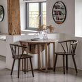 Wooden dining table with two chairs in a modern kitchen setting.