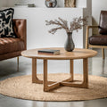 Wooden coffee table with a vase and books in a living room setting.