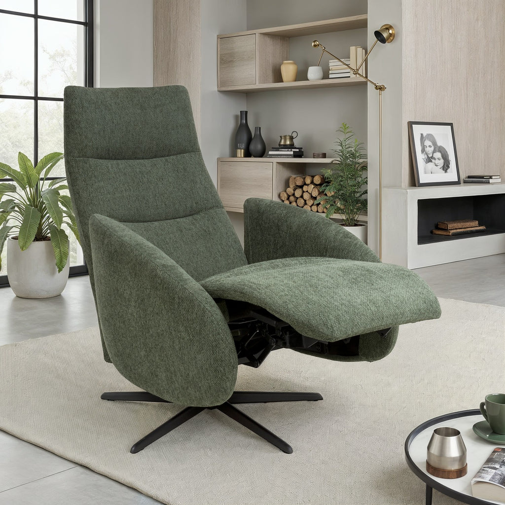 A modern sage green upholstered recliner chair with a black swivel base, shown in a styled living room setting with a rug, shelving, and plants.