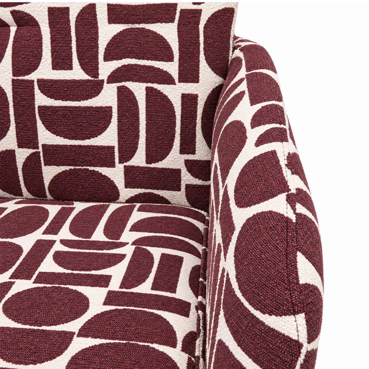Close-up of the cushioned seat and arm of the Sloane dining chair in plum geometric pattern fabric