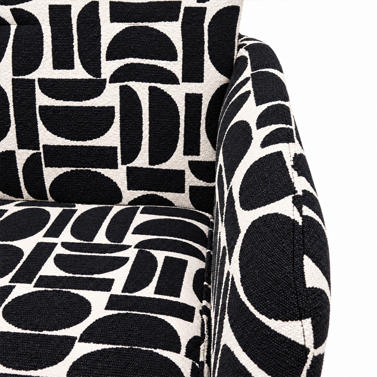 Close-up of the cushioned seat and arm of the Sloane dining chair in black geometric pattern fabric