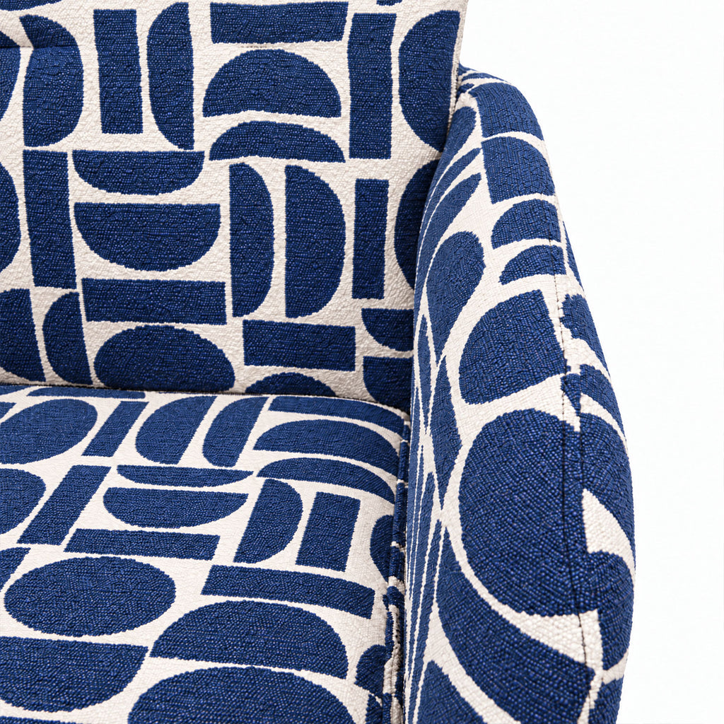 Close-up of the cushioned seat and arm of the Sloane dining chair in blue geometric pattern fabric