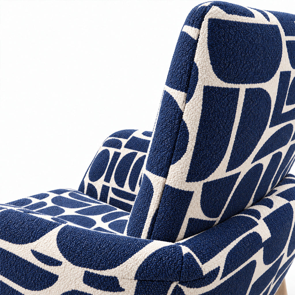 Close-up of the curved back and armrest of the Sloane dining chair in blue geometric pattern fabric
