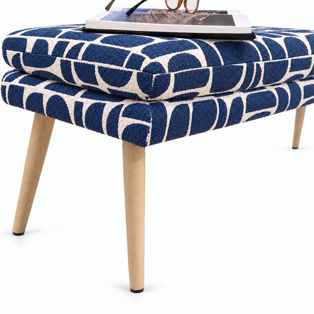 Close-up of the Sloane flat bench end and tapered wooden leg in blue geometric pattern fabric