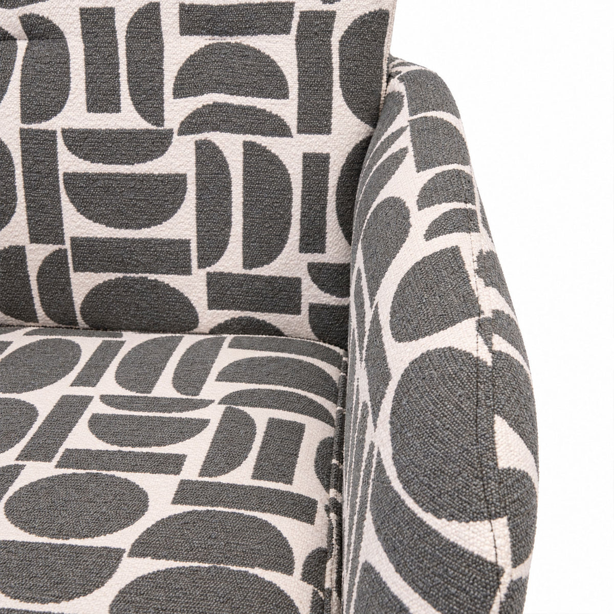 Close-up of the cushioned seat and arm of the Sloane dining chair in sage geometric pattern fabric