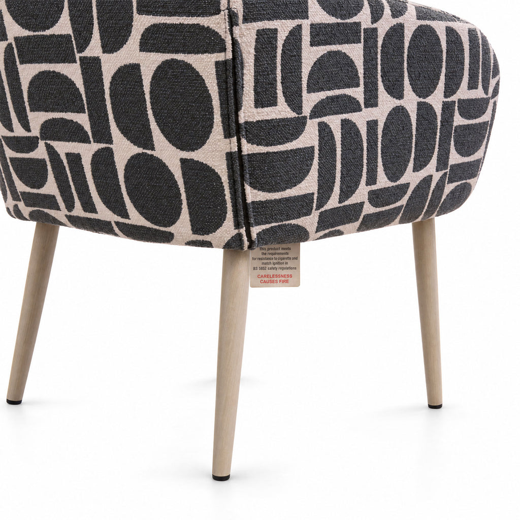 Rear view of the Sloane dining chair in sage geometric pattern fabric with tapered wooden legs