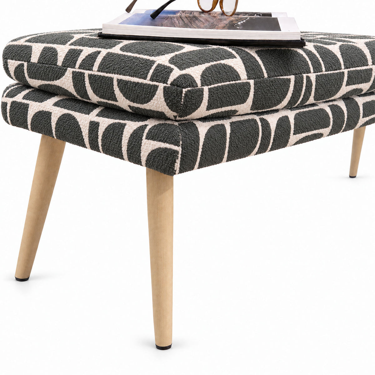Close-up of the Sloane flat bench end and tapered wooden leg in sage geometric pattern fabric