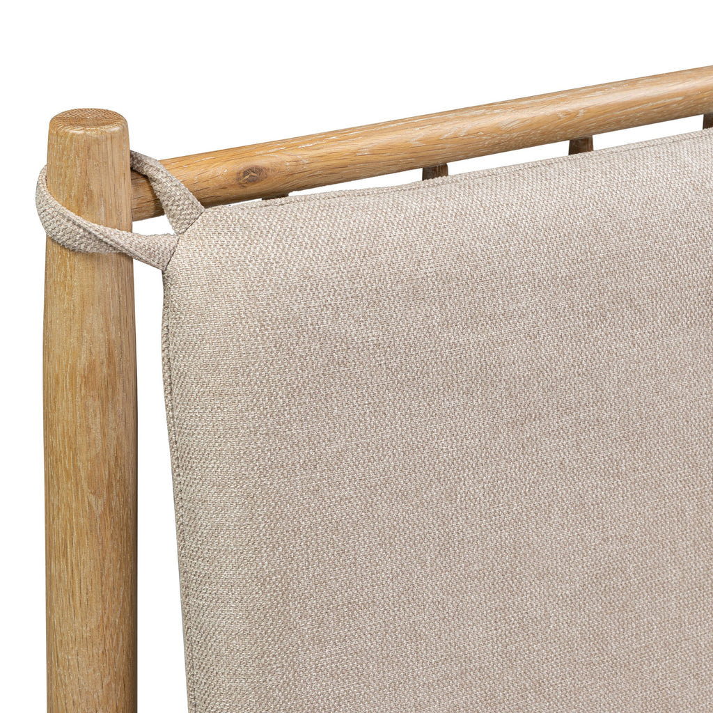 Close-up of a woven canvas sling chair with a light beige textured fabric and a natural oak wooden frame, showing the attachment loop on the left post against a white background.